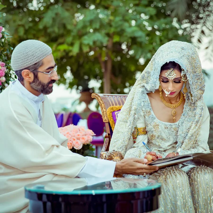 Bride signing Nikah Nama during a Muslim Nikah ceremony